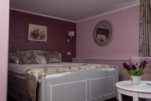 a bedroom with a bed with a mirror and a table at Pensiunea Diamant in Ghimbav