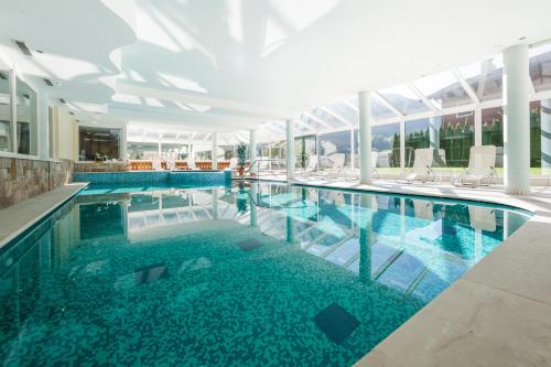 a large swimming pool with chairs in a building at Hotel Jager Hans in San Martino