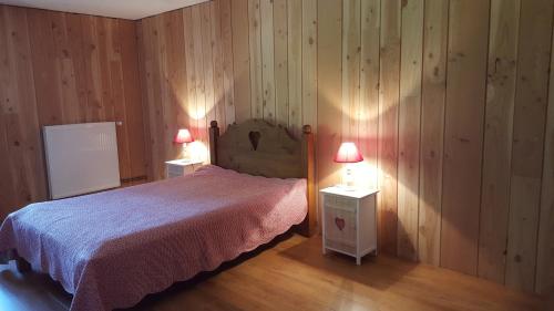 SaugeotにあるSancier gîte au calme grand terrain circuit cascades du Hérissonのベッドルーム1室(ベッド1台、ランプ付きテーブル2台付)