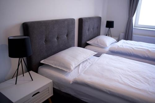 um quarto com 2 camas com lençóis brancos e almofadas em Style Hotel em Ungheni Targ
