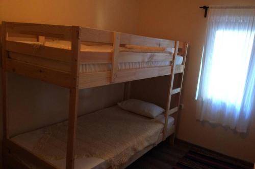 two bunk beds in a room with a window at Guest House Kostadinovi in Bŭlgarevo