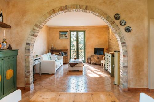 an archway in a living room with a couch and a tv at Casale Vittoria in Atri