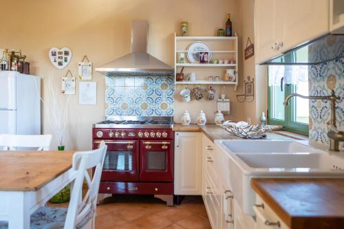 een keuken met een rode kachel en een wastafel bij Casale Vittoria in Atri