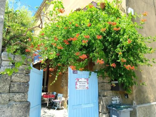 a building with a blue door with flowers on it at Chez Clairotte in Salinelles