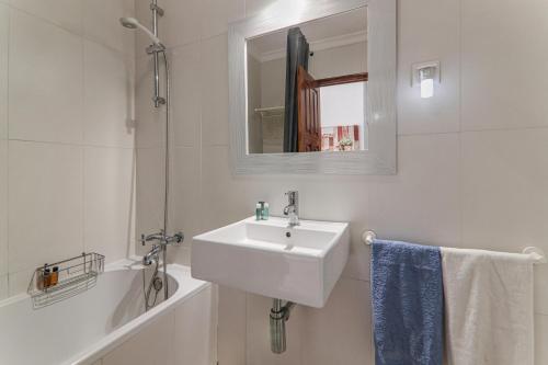 a white bathroom with a sink and a mirror at Old Village Vilamoura in Quarteira