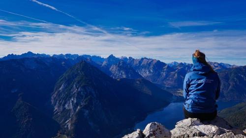 a person sitting on top of a mountain flying a kite at Hotel Post am See in Pertisau