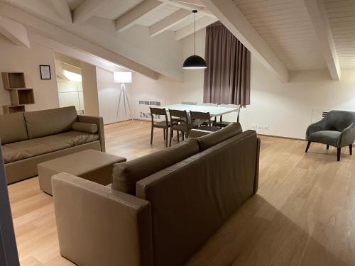 a living room with a couch and a table with chairs at Ceccarini Suite in Riccione