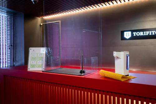 a bathroom with a red counter with a cell phone at Torifito Hotel & Pod Kanazawa in Kanazawa