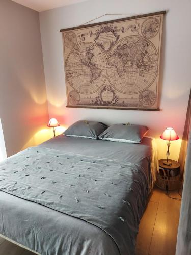 een slaapkamer met een groot bed en een kaart aan de muur bij Les Bambous in Brest
