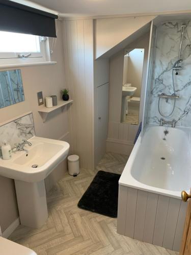 uma casa de banho branca com uma banheira e um lavatório em The Tweed in the centre of Melrose em Melrose