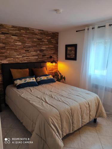 une chambre avec un grand lit avec un mur de briques dans l'établissement Appartement Giovanna, à Ceyreste