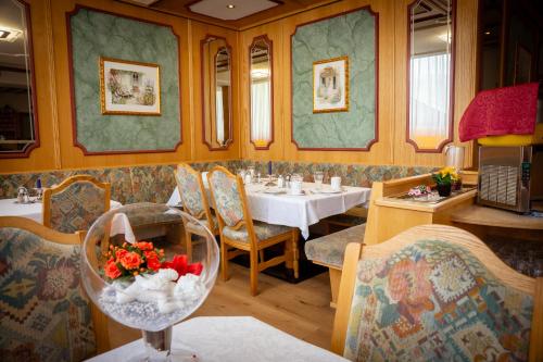 a restaurant with a table and chairs and a dining room at Ferienhotel Angerhof in Fiss