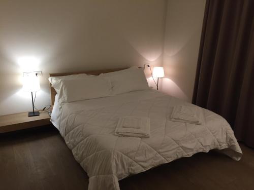 a bedroom with a white bed with two lamps at Ceccarini Suite in Riccione