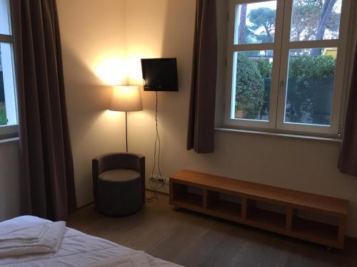 a bedroom with a bed and a chair and a lamp at Ceccarini Suite in Riccione