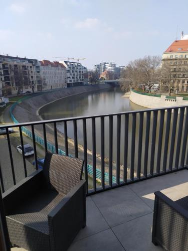 a balcony with a view of a river at ApArt Bulwary Wrocław in Wrocław