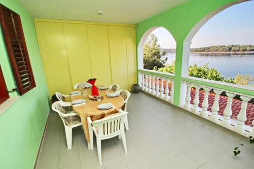 a room with a table and chairs on a balcony at Apartments Bacic in Prizba