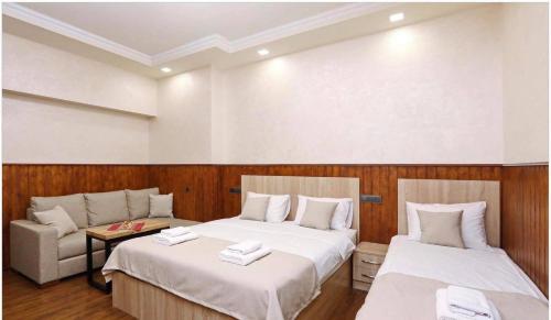 a room with two beds and a couch in it at Family Mini-Hotel Martirosyan's and tours in Yerevan