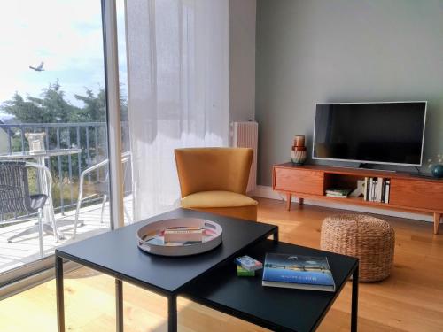 sala de estar con mesa de centro y TV en L'Océan à 100m via une venelle privée, la Ville Close à 500m, l'Archipel des Glénan à l'horizon, en Concarneau