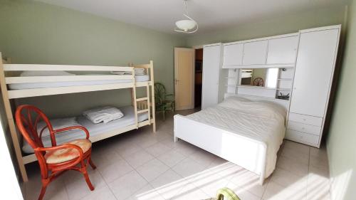 - une chambre avec 2 lits superposés et une chaise dans l'établissement ATLANTIQUE Appartement Vue Mer 1 chambre 5 personnes, à Saint-Jean-de-Monts