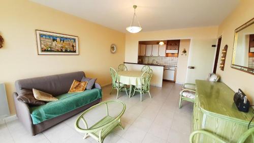 un salon avec un canapé, une table et des chaises dans l'établissement ATLANTIQUE Appartement Vue Mer 1 chambre 5 personnes, à Saint-Jean-de-Monts