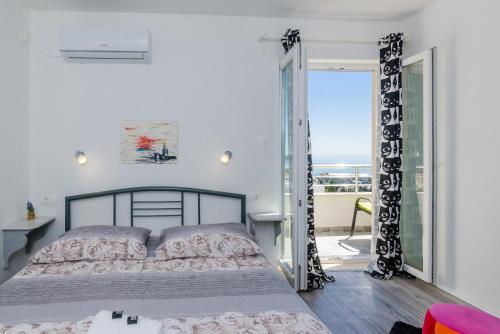 a bedroom with a bed and a view of the ocean at Guest House Nikolina in Dubrovnik