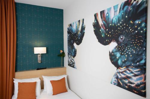 a bedroom with a bed with a painting on the wall at Hotel Continental in Angers