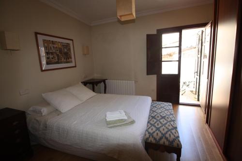 a bedroom with a white bed and a window at Casa Carrer de Bonany in Sóller