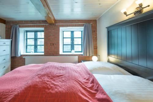 a bedroom with a large bed and two windows at Schmucke Stuuv in Rantrum