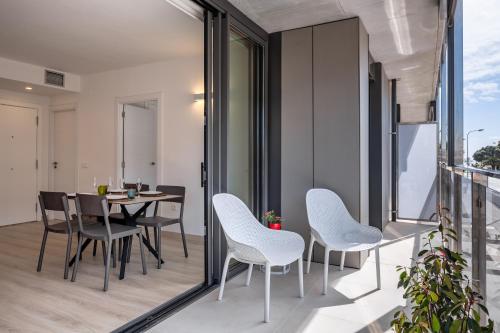 een balkon met witte stoelen en een tafel bij Apartaments La Rosella in Roses