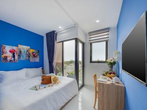 a bedroom with a large bed and a blue wall at Harmony Homestay in Da Nang