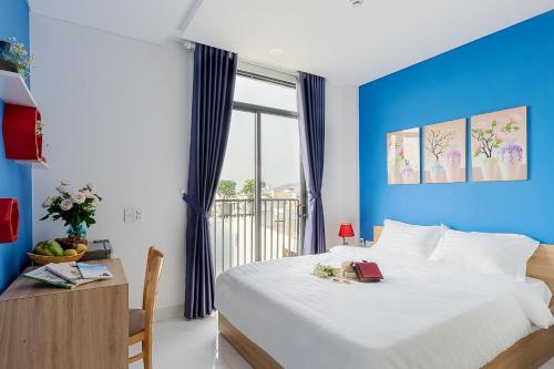 Harmony Homestay في دا نانغ: غرفة نوم بسرير كبير بجدار ازرق