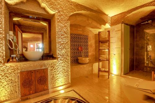 Un baño con lavabo, inodoro y espejo. en Ada Cave Suites, en Göreme