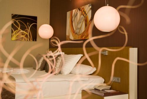 1 dormitorio con 1 cama con almohadas blancas y 2 luces en City Hotel Ankara, en Ankara
