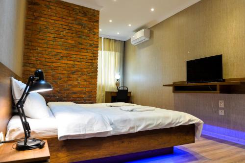 a hotel room with a bed and a television at Chateau Chikovani in Gordi