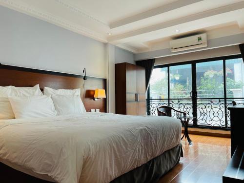 a hotel room with a bed and a balcony at The Vancouver Hotel - Ninh Binh in Ninh Binh