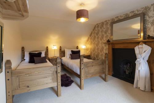 a bedroom with two twin beds and a fireplace at Rowan Cottage in Aviemore