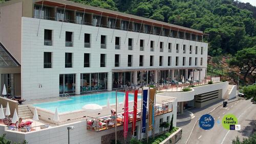 ein Hotel mit einem Pool vor einem Gebäude in der Unterkunft Hotel Uvala in Dubrovnik