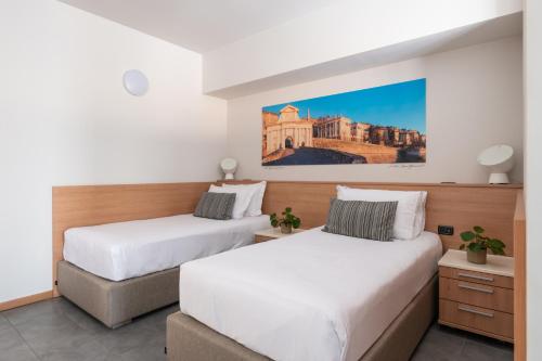 a bedroom with two beds and a painting on the wall at Hotel Borgo Brianteo in Ponte San Pietro