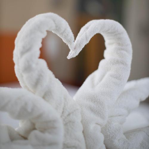 a towel shaped like a heart on a bed at Hotel Continental in Angers