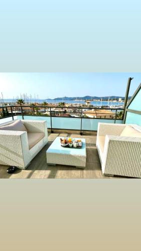 a balcony with two couches and a table on a building at Hôtel Baptistin in Le Lavandou