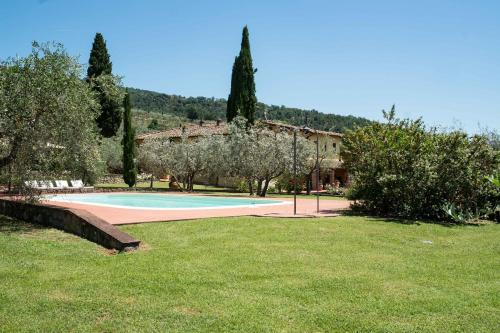 a pool in a yard with trees and a building at La Casa delle Rose in Terranuova Bracciolini