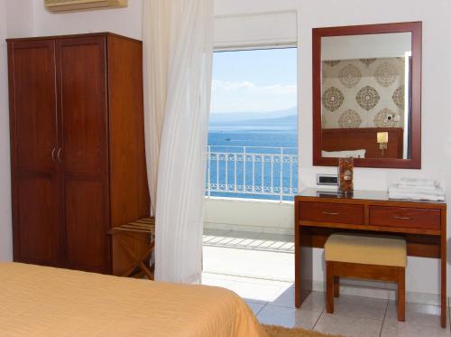 a bedroom with a bed and a dresser and a window at Anemolia Studios in Loutra Edipsou