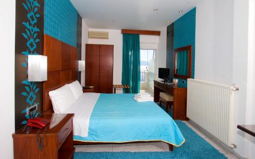a bedroom with a bed and a desk and a television at Anemolia Studios in Loutra Edipsou