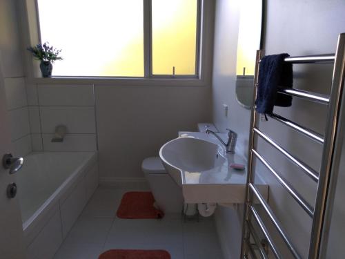 uma casa de banho com um lavatório, uma banheira e um WC. em Quiet location with view and public transport em Wellington