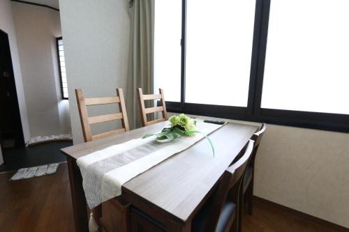 a wooden table with flowers on top of it at Liz4 Guest House Liz Nakazakicho in Osaka