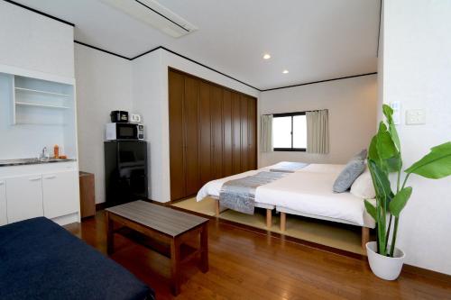a bedroom with a bed and a table in it at Liz4 Guest House Liz Nakazakicho in Osaka