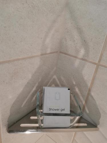 a box on a glass shelf in a tile floor at Alfa Hotel in Győr