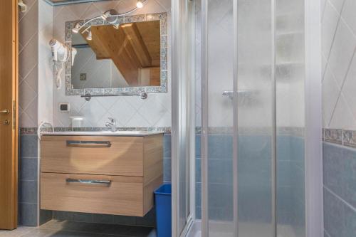 a bathroom with a shower and a sink and a mirror at Nadir - Casa Azzurra in Livigno