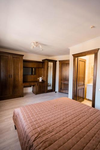 a large bedroom with a bed and wooden cabinets at Готель-ресторан Каміла in Polyana