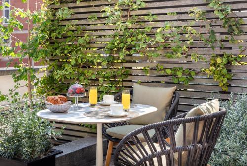 a patio with a table and chairs in front of a wall at Four Seasons Hotel London at Park Lane in London